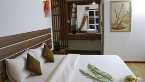 A neatly made bed with a white bedspread, a green fern leaf, and rolled towels. - Rasdhoo Wave Blue (Rasdhoo)