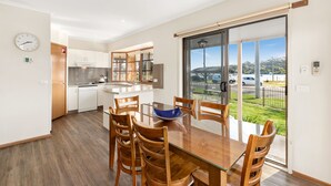 A modern kitchen with white cabinets and a stainless steel refrigerator. - Riviera Beach Resort (Lakes Entrance)