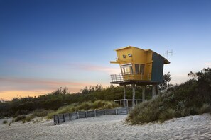 A lifeguard tower on a sandy beach with a clear sky. - Riviera Beach Resort (Lakes Entrance)