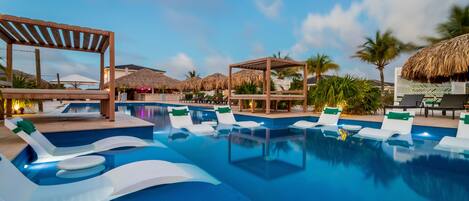 A pool area with lounge chairs and thatched umbrellas.