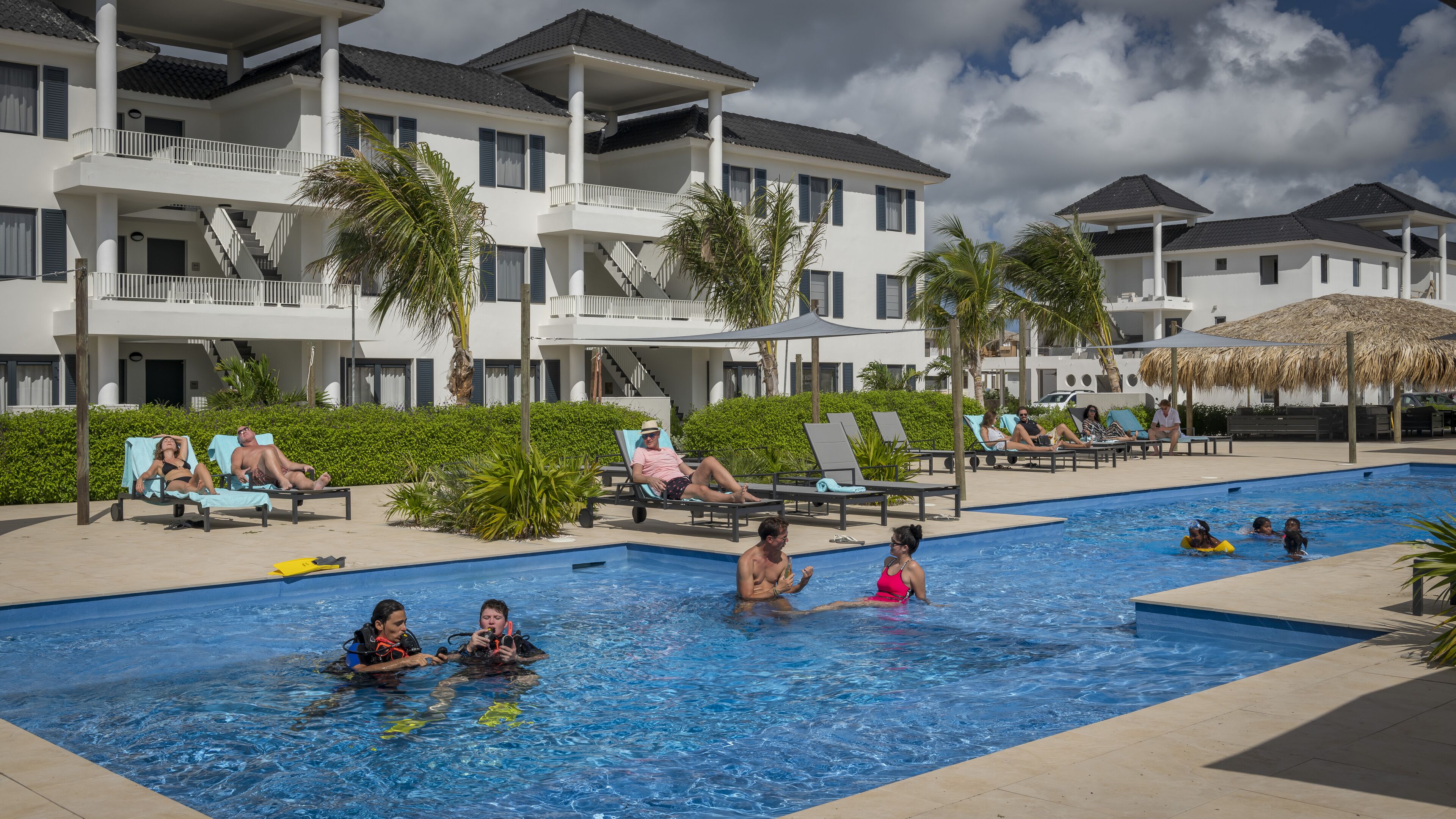 A swimming pool area with lounge chairs and a poolside bar.