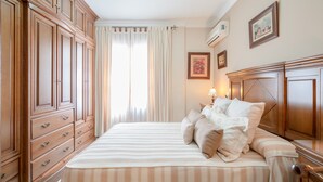 Ein Schlafzimmer mit einem großen Bett, Holzschränken und einer Deckenleuchte.