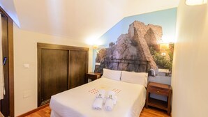 A hotel room with a bed, a wooden wardrobe, a nightstand, and a wall mural. - Ardales 2 pax by Ruralidays (Málaga)