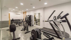 A modern gym with cardio machines, free weights, and a mirrored wall. - Ardales 2 pax by Ruralidays (Málaga)