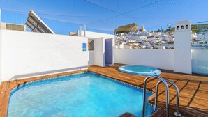A rooftop swimming pool with wooden decking and a clear view of a coastal town in the background. - Ardales 5 pax by Ruralidays (Málaga)