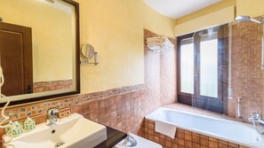 Ein Badezimmer mit Waschbecken, Spiegel und Badewanne.