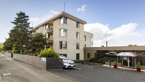 A modern apartment building with a parking area and a gated entrance. - Regent Park (Sandy Bay)