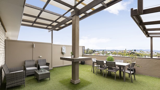 A rooftop patio with outdoor furniture, a pergola, and a view of the cityscape. - Regent Park (Sandy Bay)
