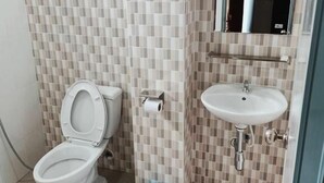 Un baño pequeño con inodoro, lavabo y espejo.