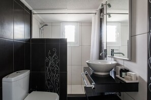 Un baño moderno con inodoro, lavabo y ducha.