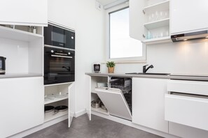 Classic Apartment | Private kitchen | Stovetop, electric kettle - Apartamenty InPoint Mogilska Tower (Kraków)