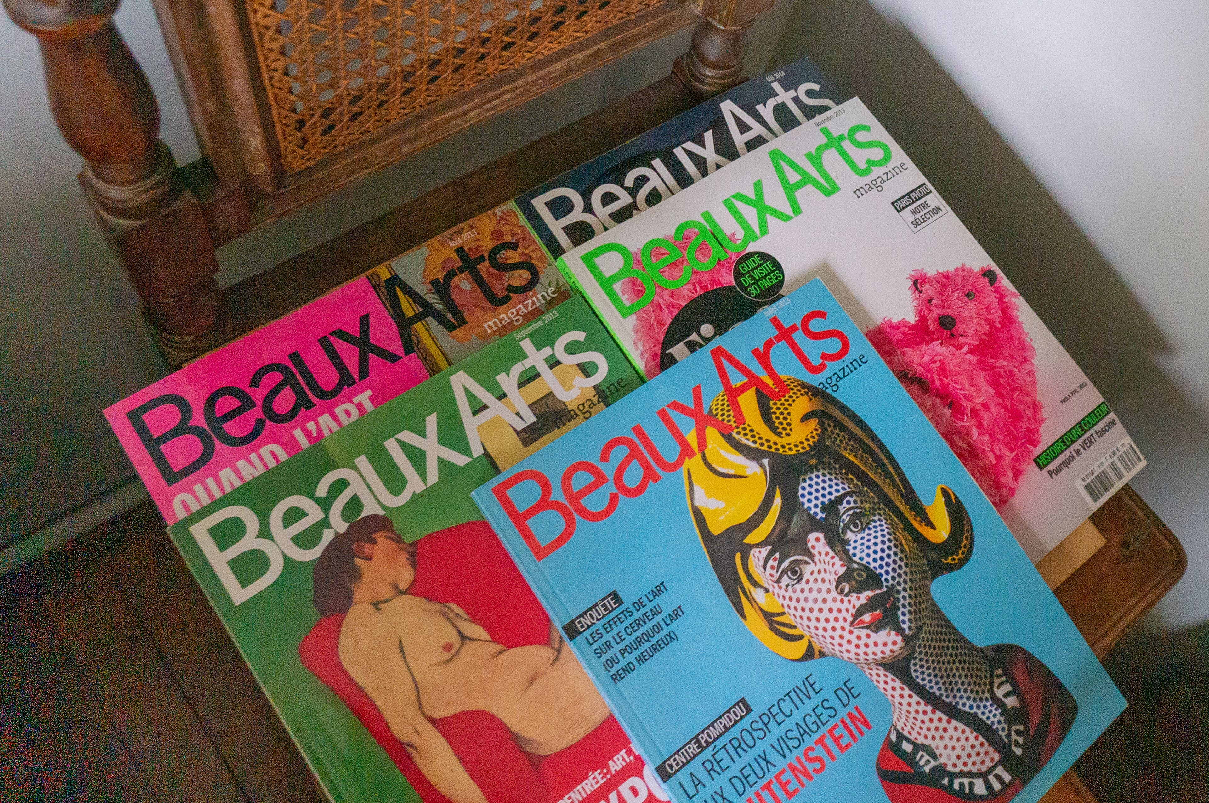 Una selezione di copertine della rivista 'Beaux Arts' su un tavolo di legno.