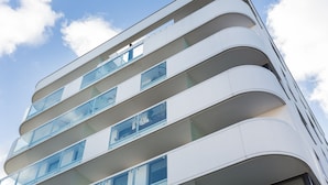 Un edificio moderno de varios pisos con balcones y ventanas grandes.