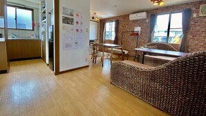 Une chambre d’hôtel moderne dotée d’un coin cuisine, d’une table à manger et d’un espace salon avec un canapé à motifs.