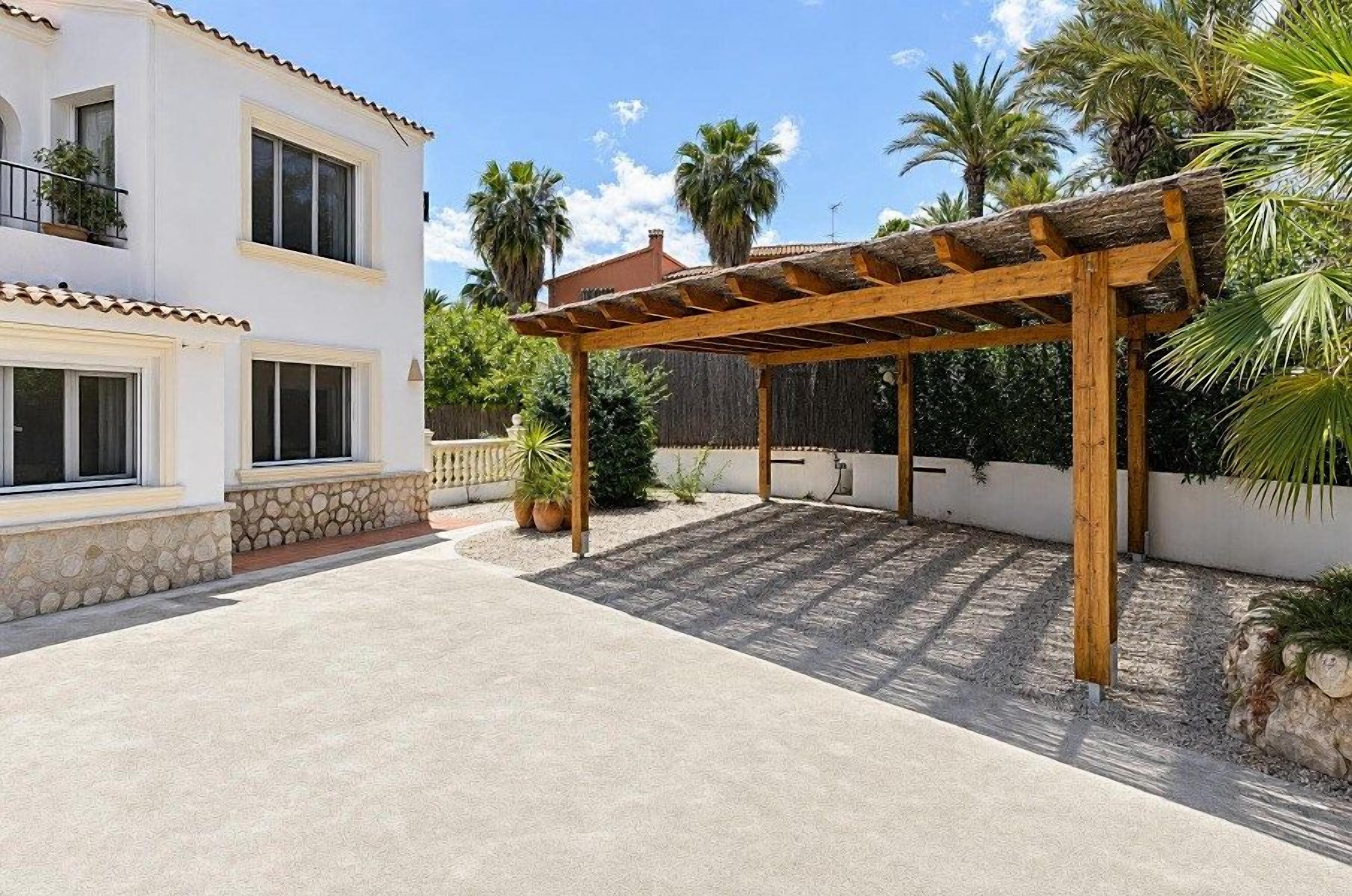 Een gebouw met twee verdiepingen, een overdekte patio, stenen trappen en een houten pergola.