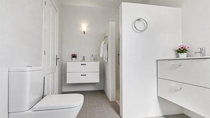 A modern bathroom with a toilet, a sink, and a shower area. - Large and comfortable villa in Moraira, Costa Blanca, Spain  with heated pool for 12 persons (Moraira)