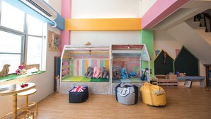 A children's playroom with colorful walls, a playhouse, and various toys. - Anping Pet Island (Tainan)