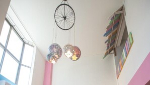A children's play area with colorful walls, a loft bed, and a hanging light fixture. - Anping Pet Island (Tainan)