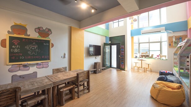 A classroom with wooden furniture, a chalkboard with Wi-Fi details, and a window with a view of the outside. - Anping Pet Island (Tainan)