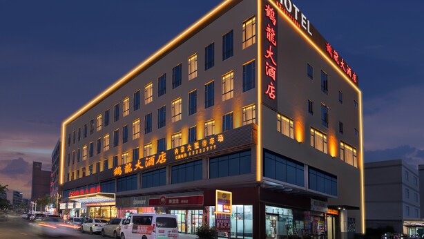 Un hotel con varios pisos, grandes ventanales y un cartel llamativo que indica que es un hotel.