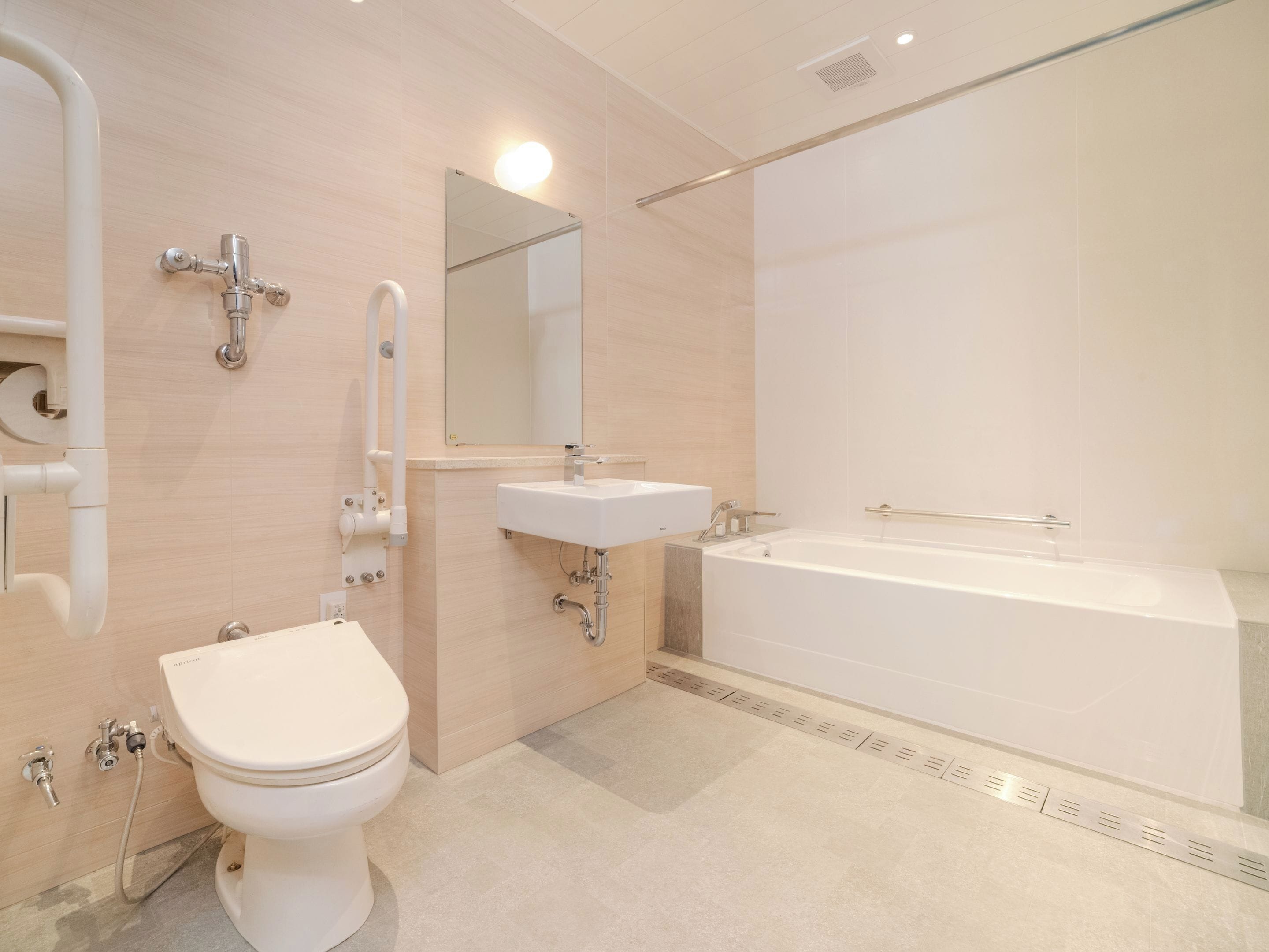 A modern bathroom with a toilet, sink, and bathtub.
