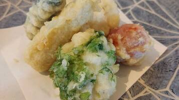 A plate of food with various items including a breaded item, a green vegetable, and a round item.