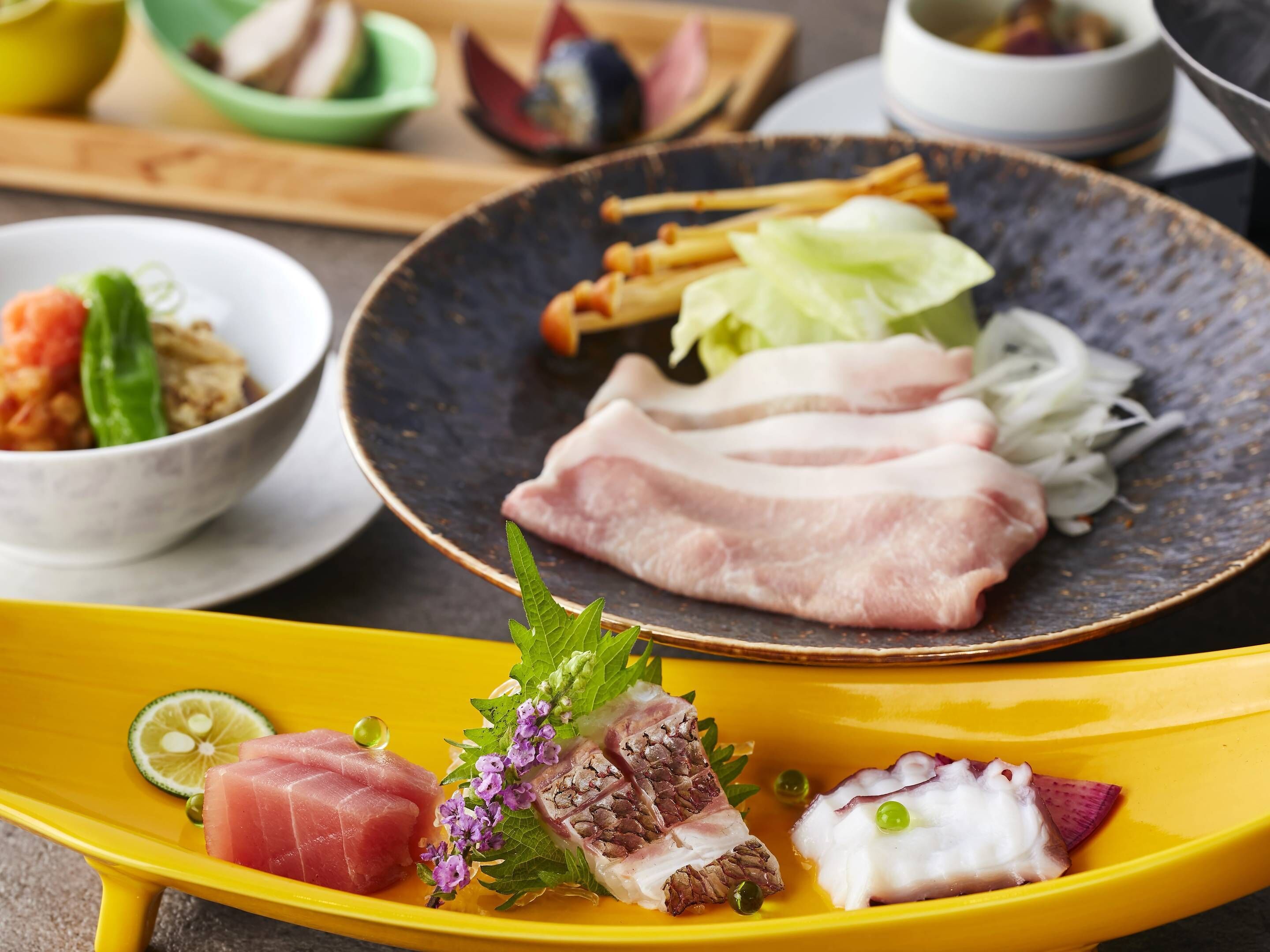 A variety of food items on a yellow plate, including slices of meat and vegetables.