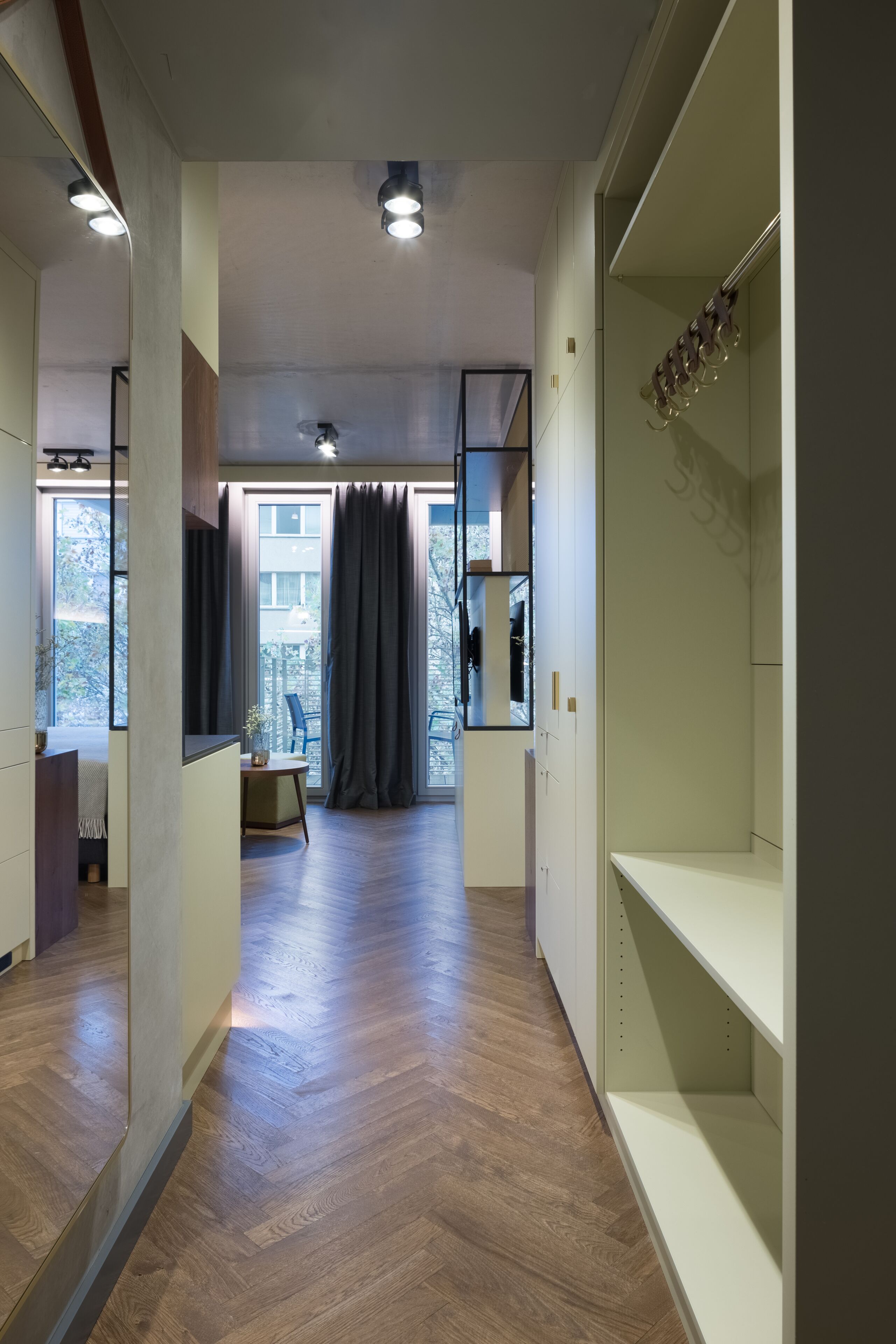Un intérieur moderne avec un plancher en bois, un coin repas comprenant une table et des chaises, et une grande fenêtre agrémentée de rideaux.