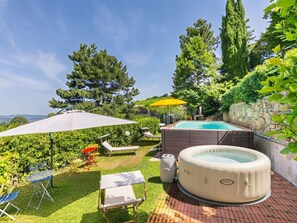 A backyard with a hot tub, lounge chairs, and a small table. - Ridaldi by Interhome (Greve in Chianti)