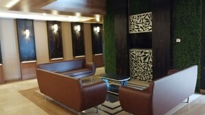 A modern waiting area with leather seating, a small table, and a decorative wall panel. -  Hotel The Bentree, Bhopal (Bhopal)