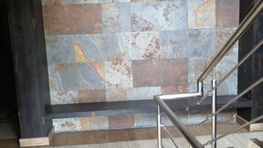 A staircase with metal railings leading to a landing with a textured wall. -  Hotel The Bentree, Bhopal (Bhopal)