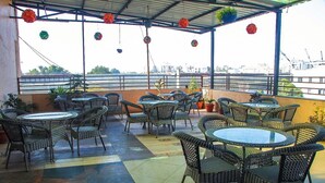An outdoor patio area with wicker furniture and potted plants. -  Hotel The Bentree, Bhopal (Bhopal)