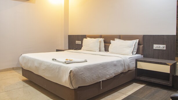 A modern hotel room with a large bed, a bedside table, and an air conditioning unit on the wall. -  Hotel The Bentree, Bhopal (Bhopal)