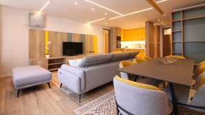 Una sala moderna con un sofá, un reposapiés y una mesa de comedor con sillas.