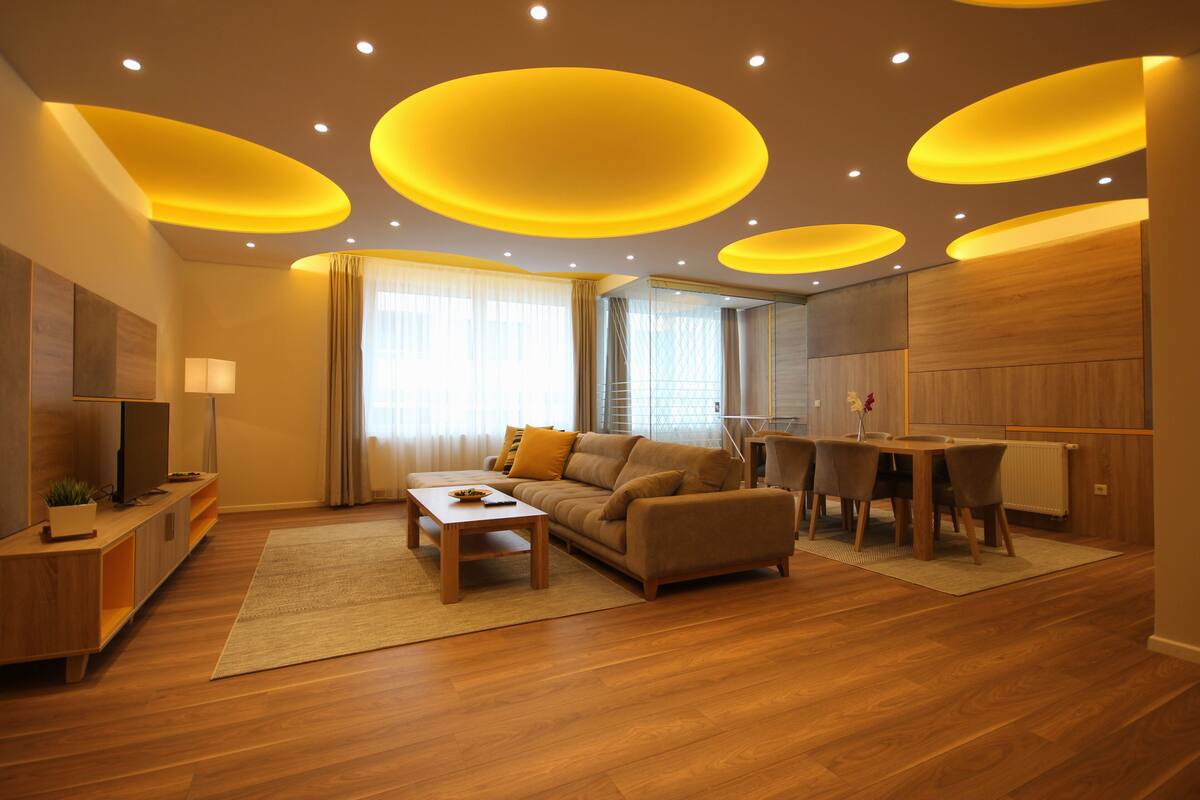 A modern living room with a sofa, coffee table, and dining table.