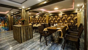 Un restaurant doté d’un sol en marbre, de boiseries et d’un bar central.
