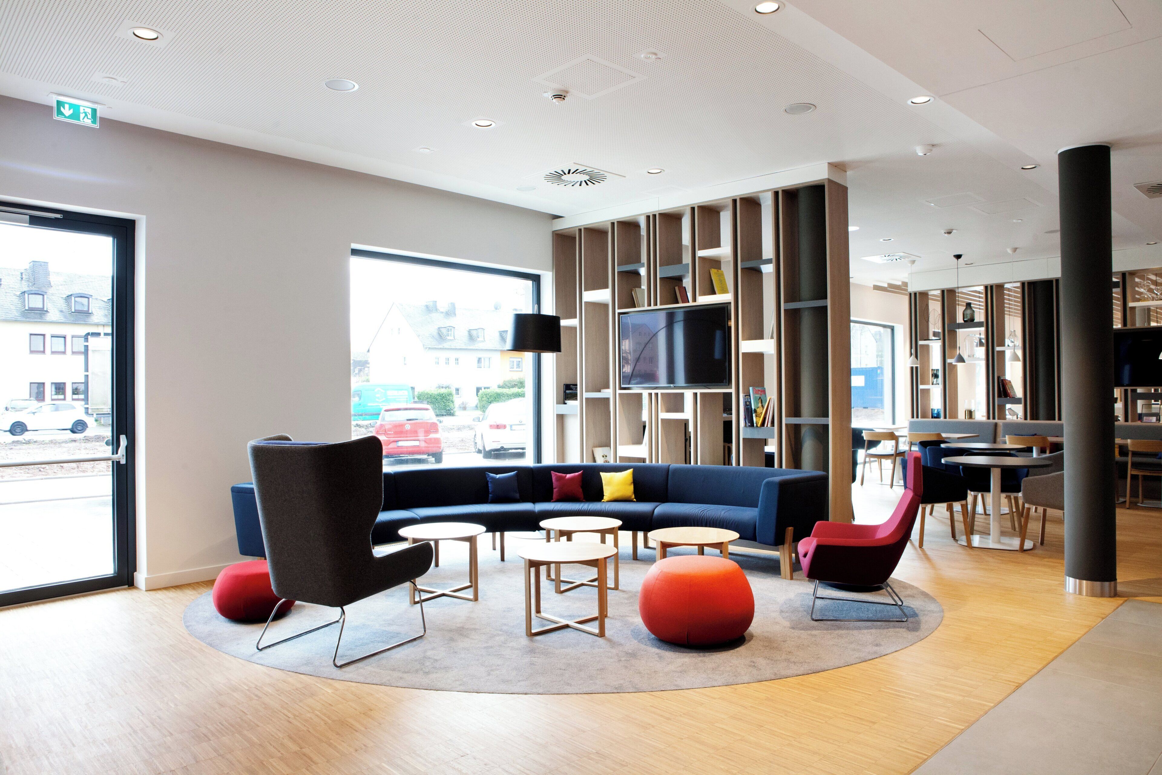 A modern lounge area with a sofa, chairs, and a TV.
