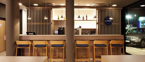 A modern bar area with wooden bar stools, a counter with a coffee machine, and a sign indicating it is an Express Cafe & Bar.