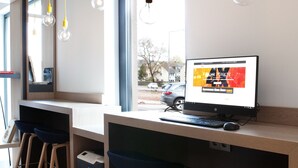 Un espacio de trabajo moderno con escritorio, computadora y dos taburetes.