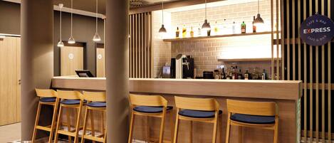 Zona de bar con mostrador, taburetes y un cartel que dice 'EXPRESS CAFE & BAR'.