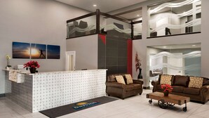 A hotel reception area with a reception desk, two sofas, a coffee table, and a large window with a view. - Days Inn by Wyndham Wainwright (Wainwright)