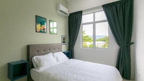 Une chambre à coucher comprenant un lit, une table de chevet, une fenêtre avec des rideaux et deux tableaux accrochés au mur.