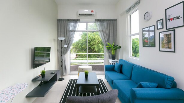 Un salon moderne avec un canapé bleu, un téléviseur à écran plat, une table basse et une grande fenêtre avec des rideaux.