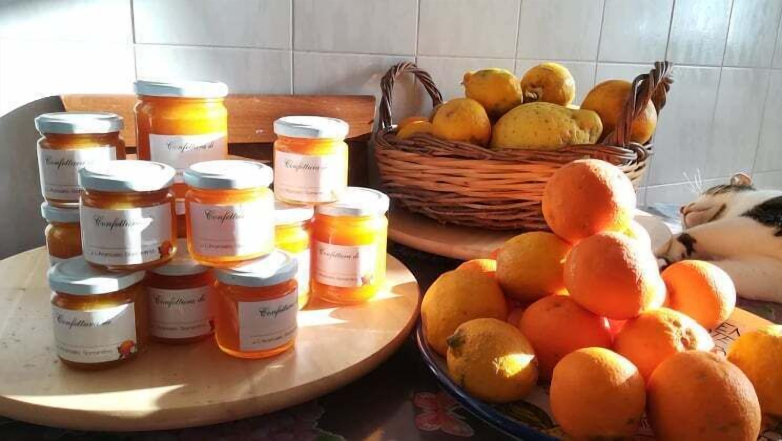 Jars of honey and a basket of lemons on a table.