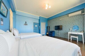 A hotel room with two beds, a desk, a chair, a television, and a wall-mounted air conditioner. - Maji Homestay (Taitung)