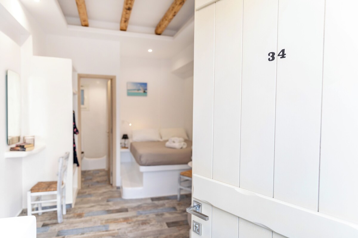 Un dormitorio con cama, armario y escritorio.