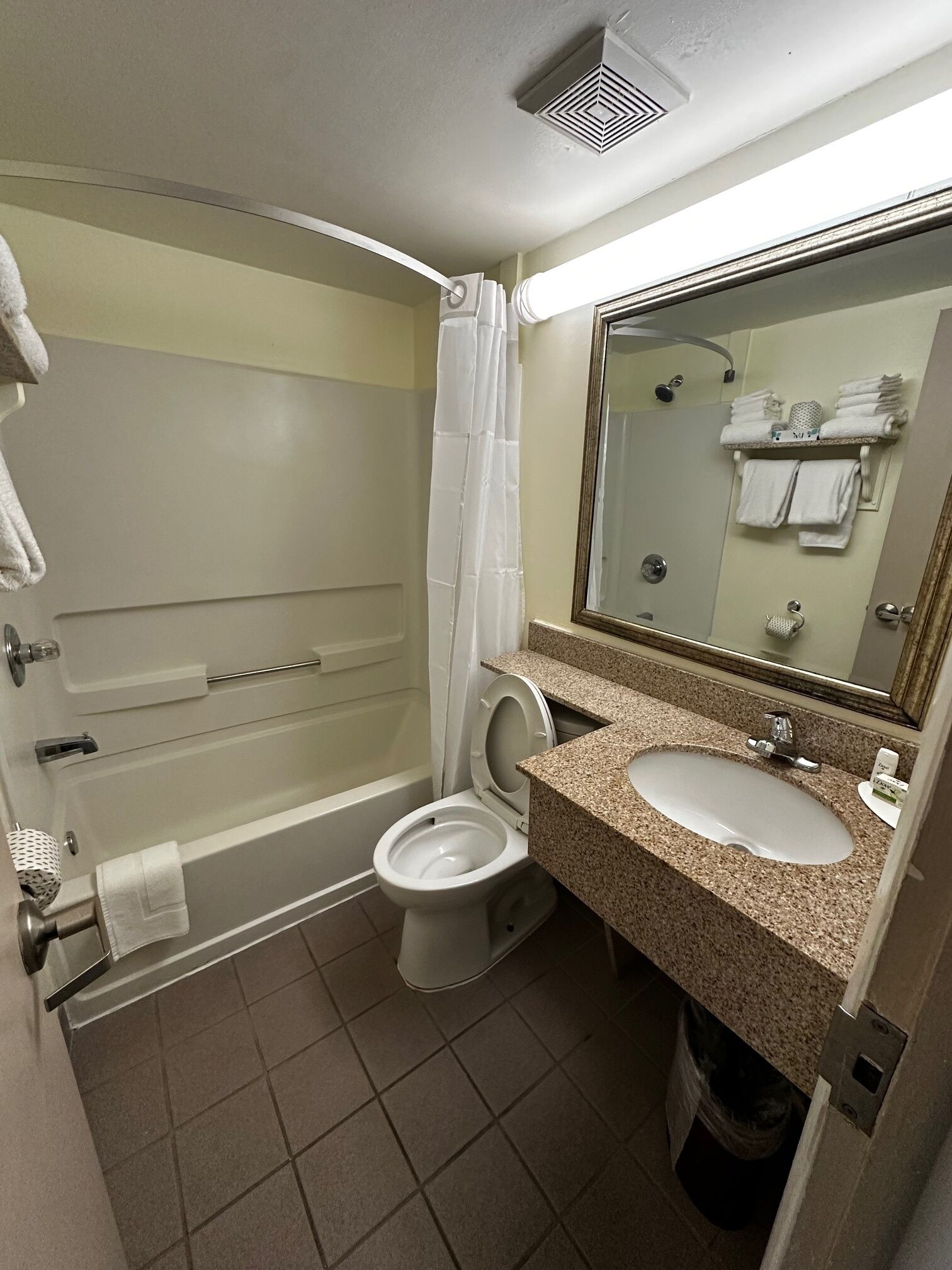 A bathroom with a bathtub, toilet, sink, and a mirror.