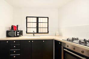 A kitchen with a microwave, stove, sink, and cabinets.