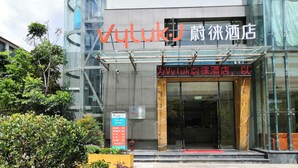 A hotel entrance with a modern glass facade, a signboard with hotel name, and a red carpet leading to the entrance. - Vyluk J Hotel Fuxing Road Lijiang (Lijiang)