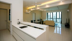 Een moderne keuken met een centraal eiland, inbouwverlichting en een zithoek met een bank en tafel.